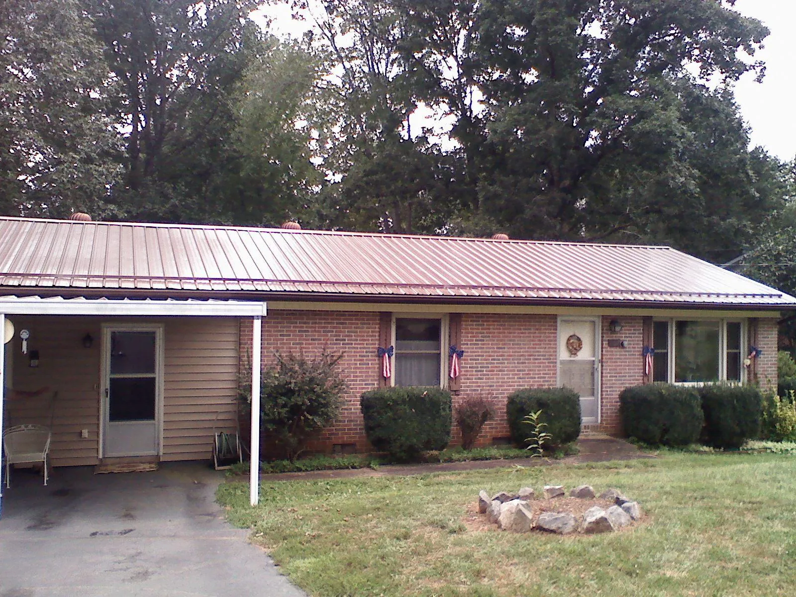 Bronze metal roof and carport on a brick ranch home — Roof Repair work by our crew in Ithaca